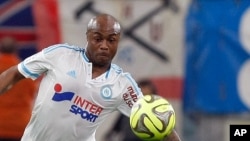 L'attaquant ghanéen de Marseille André Ayew, à droite, tente un dribble face le défenseur italien Andrea Raggi lors d'un match de football entre Marseille et Monaco au Stade du Vélodrome, à Marseille, 10 mai 2015.