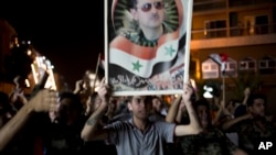 FILE - Syrian soldiers celebrate Bashar al-Assad's presidential re-election, in Damascus, Syria, June 4, 2014.