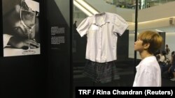 A visitor at an exhibition featuring clothing worn by victims at the time of sexual assault in Bangkok, Thailand, June 29, 2018.