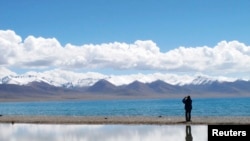 FILE - A tourist takes pictures in the Tibet Autonomous Region, Sept. 14, 2011. 