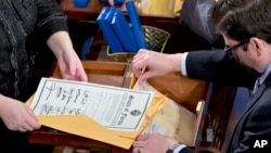 Un empleado abre los certificados de resultados durante el recuento de votos en 2013.