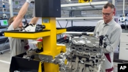 FILE - Workers complete a new diesel engine at the MDC Power GmbH, a company of the German Daimler AG, in Koelleda, Germany, Oct. 23, 2015.
