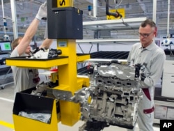 FILE - Workers complete a new diesel engine at the MDC Power GmbH, a company of the German Daimler AG, in Koelleda, Germany, Oct. 23, 2015.