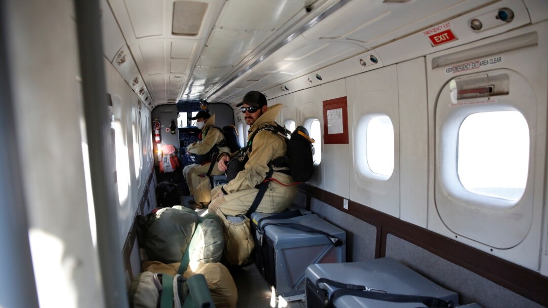 Nate Rose, and Ned Barnett, sit inside the Dornier 228 plane headed to McCall in Idaho at the West Yellowstone Smokejumper base in West Yellowstone, Montana, Aug.10, 2021.