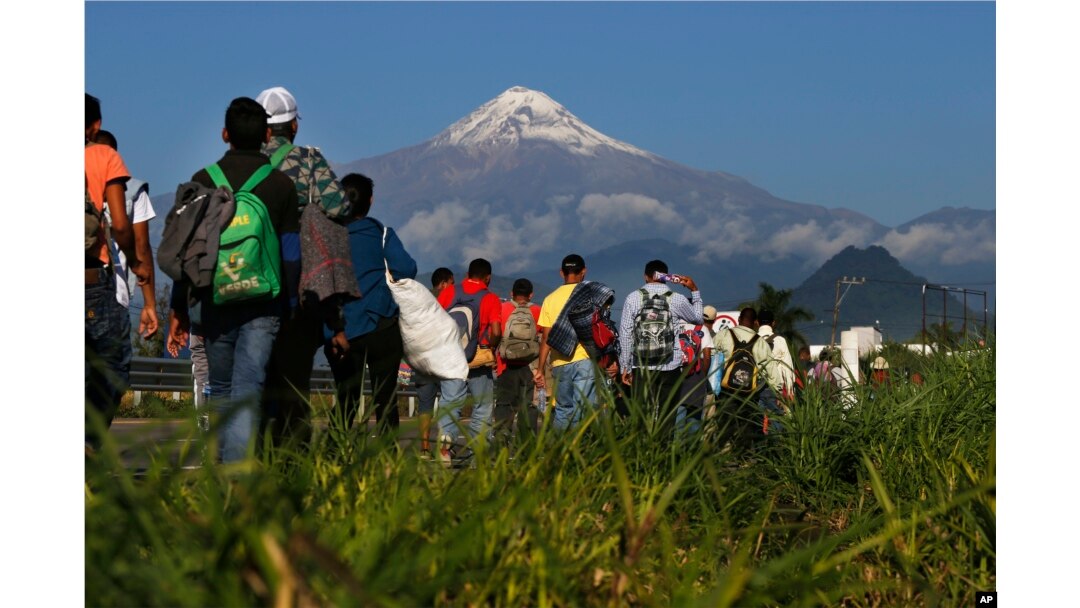 Central American migrants begin their morning trek as part of a thousands-strong caravan hoping to reach the U.S. border, as they face the Pico de Orizaba volcano upon departure from Cordoba, Mexico, Monday, Nov. 5, 2018.