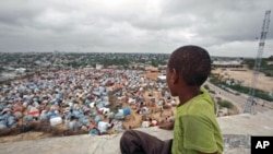 A boy sits looking over the Seyidka settlement for the famine-stricken internally displaced people in Berkulan, near Somalia's capital Mogadishu, September 6, 2011.