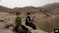 In this July 30, 2018, photo, a 17-year-old boy holds his weapon in High dam in Marib, Yemen. Experts say child soldiers are “the firewood” in the inferno of Yemen’s civil war, trained to fight, kill and die on the front lines.