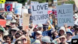 FILE - People hold up signs and shout while listening to speakers during a rally against hate in Berkeley, Calif., Sunday, Aug. 27, 2017.