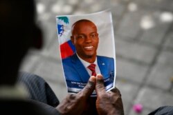 Seseorang memegang foto mendiang Presiden Haiti Jovenel Moise saat upacara peringatannya di Museum Pantheon Nasional di Port-au-Prince, Haiti, 20 Juli 2021. (Foto: AP)