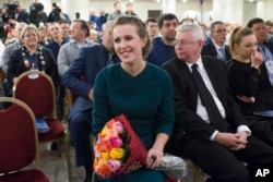 Russian celebrity TV host Ksenia Sobchak, who wants to challenge Russian President Vladimir Putin in the March 18 presidential election, smiles after receiving a bouquet of flowers at the meeting of her supporters in Moscow, Russia, Dec. 23, 2017.