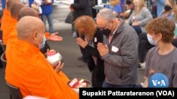 Participants pray as they offer food to Buddhist monks in a demonstrated workshop for a group of the AFS exchange students and volunteers during the AFS Thai Town Tour, a day-long tour of Thai Town hosted by the Thai Town Council Of Los Angeles, CA. 