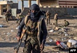 Fighters with the Syrian Democratic Forces (SDF) are pictured in the town of Baghuz, Syria, on the front line of fighting to expel the Islamic State group from the area, March 12, 2019.