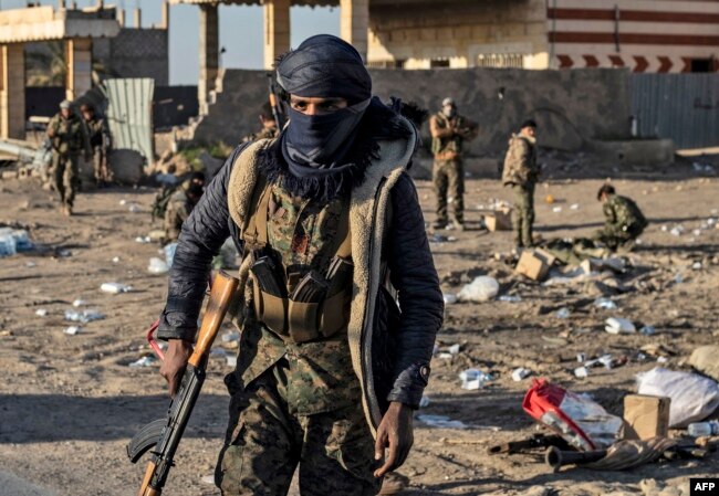 Fighters with the Syrian Democratic Forces (SDF) are pictured in the town of Baghuz, Syria, on the front line of fighting to expel the Islamic State group from the area, March 12, 2019.