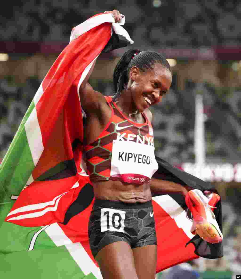 Faith Kipyegon, of Kenya celebrates after winning gold after the final of the women&#39;s 1,500-meters at the 2020 Summer Olympics, Friday, Aug. 6, 2021, in Tokyo, Japan. (AP Photo/Charlie Riedel)