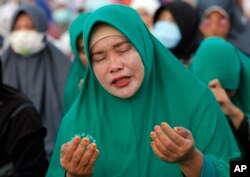 A Muslim woman prays during a special prayer for the victims of earthquake and tsunami at Talise beach in Palu, Central Sulawesi, Indonesia, Oct. 5, 2018.