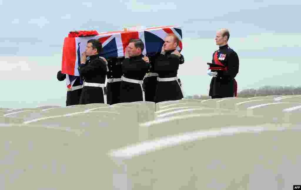 A coffin containing the remains of a British soldier is carried in the Honorable Artillery Company Cemetery at Ecoust-Saint- Mein as four British soldiers were laid to rest with full military honors in northern France, nearly a century a century after they were killed in action in World War I. Their bodies were discovered in 2009 when a local farmer was clearing one of his fields.