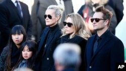 FILE - French rock star Johnny Hallyday's wife Laeticia, second left, his daughters Jade, left, and Joy, Laura Smet, second right, and son David Hallyday, right, arrive at La Madeleine church for Johnnny Hallyday's funeral ceremony in Paris, Dec. 9, 2017. 
