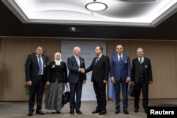 UN Special Envoy for Syria Staffan de Mistura (3rd L) shakes hands with head of the Syrian Negotiation Commission (SNC) Nasr al-Hariri (3rd R) next to opposition delegation members (from L-R) Khaled al-Mahamid, Hanadi Abu Arab, Jamal Suliman and Safwan Akash, on the opening of a new round of Syria's peace talks at the United Naitons Office in Geneva, Switzerland, Nov. 28, 2017.