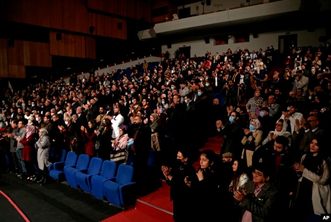 The audience stands for Iraqi virtuoso oud player Naseer Shamma as he performs, at the Iraqi National Theater in Baghdad, Iraq, Friday, Jan. 21, 2022. (AP Photo/Hadi Mizban)