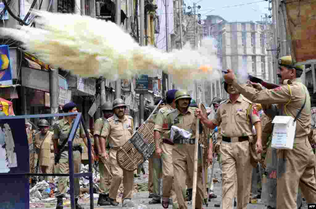 An Indian policeman fires a teargas shell during a clash between protesters and police officials in Jammu. A town in the south of Indian Kashmir was under curfew for a second day after two people were killed and dozens wounded&nbsp;in Hindu-Muslim clashes in the disputed Himalayan region, police said.