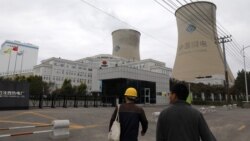 People walk past a China Energy coal-fired power plant in Shenyang, Liaoning province, China Sept. 29, 2021.