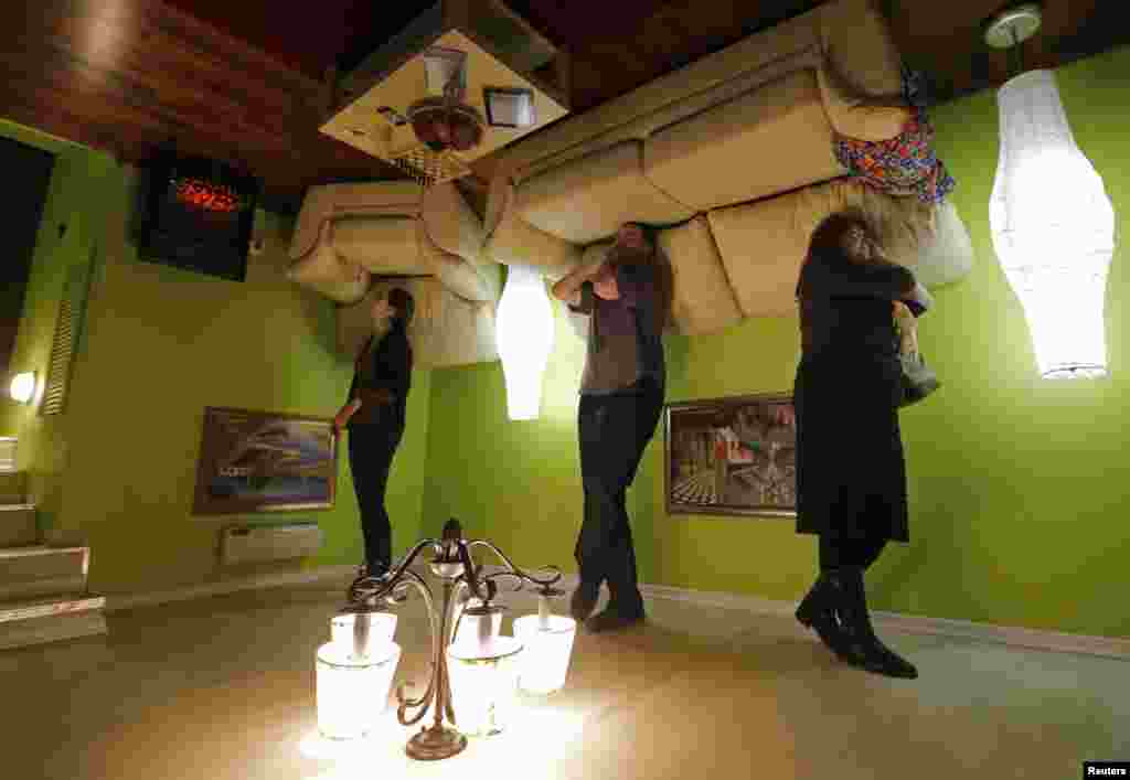People take a tour in an &quot;upside down home&quot; in St. Petersburg, Russia. The exhibition charges less than $10 for a walk through three-room and two-bathroom house.