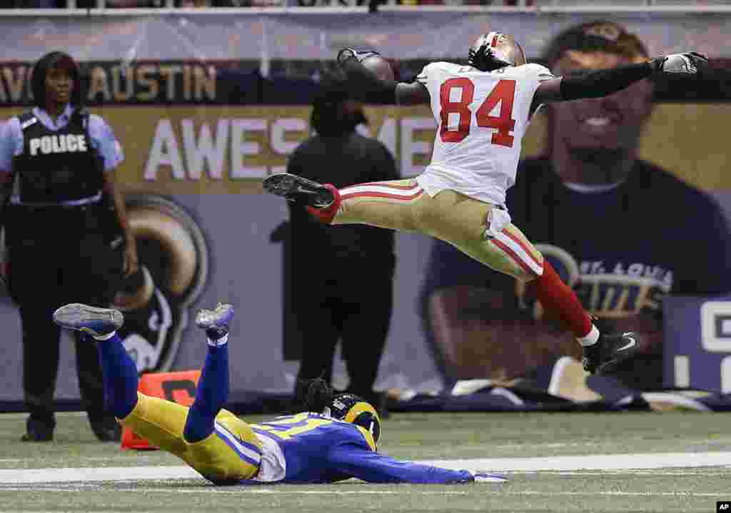 San Francisco 49ers wide receiver Brandon Lloyd (84) jumps into the end zone ahead of St. Louis Rams cornerback Janoris Jenkins (21) as Lloyd scores a touchdown on an 80-yard pass play in the second quarter of an NFL football game in St Louis, Missouri, USA, Oct. 13, 2014.