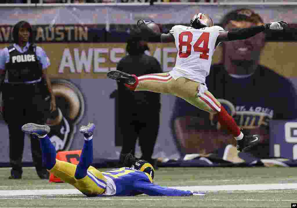 San Francisco 49ers wide receiver Brandon Lloyd (84) jumps into the end zone ahead of St. Louis Rams cornerback Janoris Jenkins (21) as Lloyd scores a touchdown on an 80-yard pass play in the second quarter of an NFL football game in St Louis, Missouri, USA.