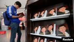 FILE - A man leafs through a book on China's former premier Zhu Rongji, published in 2011, at a bookstore in Beijing.