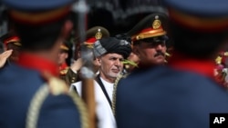 FILE - Afghan President Ashraf Ghani (C) inspects an honor guard during the Independence Day celebrations in Kabul, Afghanistan, Aug 18, 2016. The peace deal with Hekmatyar's group could provide a boost to the beleaguered Ghani.