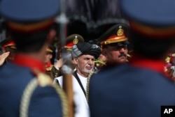 Afghanistan's President Ashraf Ghani, center, inspects the honor guard during the Independence Day celebrations at the Defense Ministry in Kabul, Afghanistan, Thursday, Aug 18, 2016.