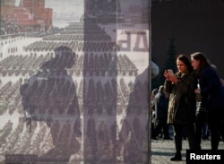 FILE - Two women are seen near a display after a military parade in Red Square, Moscow, Russia Nov. 7, 2018.