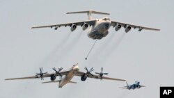  file photo shows a Russian Il-76 air tanker, top, demonstrating refueling a Tu-95 bomber, bottom, as they fly above the Moscow Red Square, during the annual Victory Day parade. (AP Photo/Alexander Zemlianichenko, Pool)