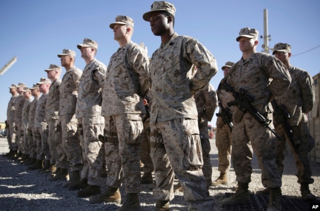 FILE - U.S. Marines stand guard during a change-of-command ceremony at Task Force Southwest military field in Shorab military camp of Helmand province, Afghanistan, Jan. 15, 2018.