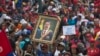A government supporter holds up a framed image of President Nicolas Maduro during an anti-imperialist rally in Caracas, Venezuela, Saturday, March 30, 2019. 