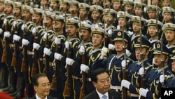Japanese Prime Minister Yoshihiko Noda, right, and Chinese Premier Wen Jiabao inspect a guard of honor during a welcoming ceremony at Great Hall of the People in Beijing, China, December 25, 2011.