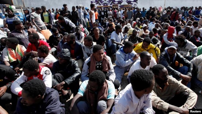 Illegal African migrants sit during a visit by U.N. officials at a detention camp in Tripoli, Libya, March 22, 2017.