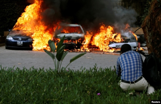 Cars are seen on fire at the scene of explosions and gunshots in Nairobi, Kenya January 15, 2019.