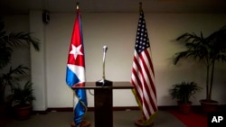 FILE - A U.S. and Cuban flag are seen at a podium. Both countries reestablished diplomatic relations earlier this year following a half century of estrangement.