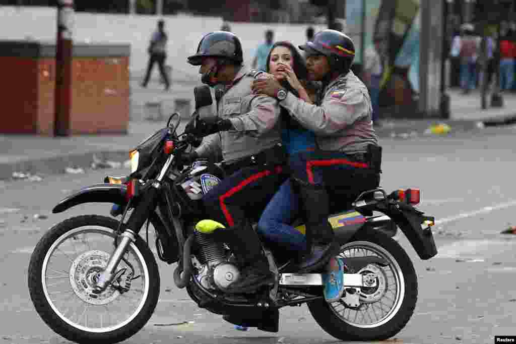 An anti-government protester is detained by police during clashes with security forces at Altamira square in Caracas, Venezuela, Mar. 6, 2014.