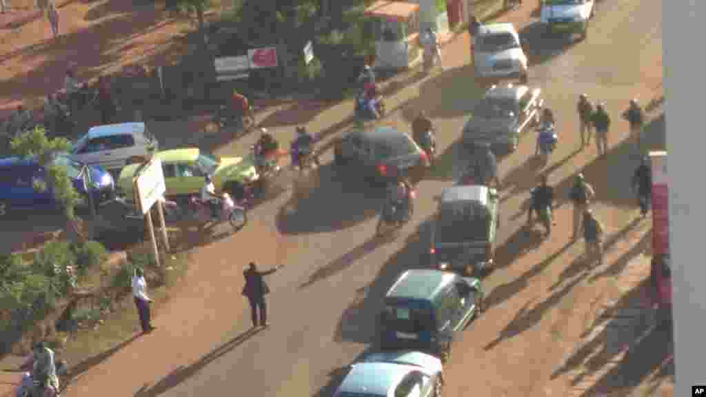 Mutane su na gudu daga hotel din Radisson Blu Hotel na Bamako, Mali, Jumma&#39;a, Nov. 20, 2015.