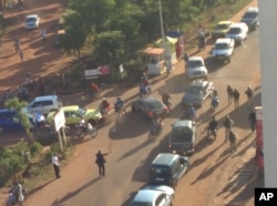 In this image made available by Malikahere.com security personnel, right, arrive close to the scene of an attack on a hotel in Bamako, Mali, Nov. 20, 2015.