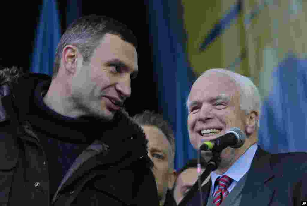 Legislator oposisi dan juara tinju kelas berat WBC Vitali Klitschko berbicara dengan Senator Amerika John McCain selama protes pro-UE di Lapangan Kemerdekaan di Kiev, 15 Desember 2013.