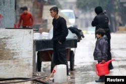 Civilians fill containers with water in a rebel-held besieged area of Aleppo, Syria, Dec. 14, 2016.