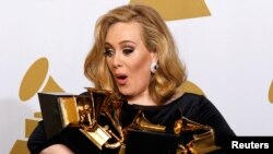 FILE - Singer Adele holds her six Grammy Awards at the 54th annual Grammy Awards in Los Angeles, California February 12, 2012. 
