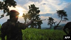 FILE - A soldier points to the limits of rebel-held territory from the Kavumu hill in North Kivu, eastern Democratic Republic of the Congo, June 3, 2012.