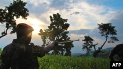 FILE - A soldier points to the limits of rebel-held territory from the Kavumu hill in North Kivu, eastern Democratic Republic of the Congo, June 3, 2012.