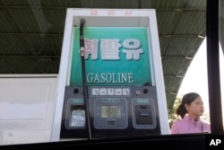 FILE - A gas attendant waits by a pump at a gas station in Pyongyang, North Korea, April 26, 2017. While world attention has focused on Kim Jong Un’s recent missile tests, a surge in gasoline prices that has hit Pyongyang is showing no signs of letting up