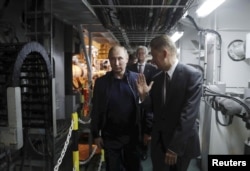 FILE - Russian President Vladimir Putin and Gazprom Chief Executive Alexei Miller inspect the work on the Turkish Stream gas pipeline project aboard the Pioneering Spirit pipeline-laying ship in the Black Sea near Anapa, Russia, June 23, 2017.