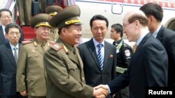 Choe Ryong-Hae, left, director of the General Political Bureau of the Korean People's Army (KPA) of North Korea, shakes hands with Chinese official upon arrival at the airport, Beijing, May 22, 2013.